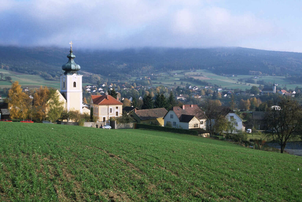 Eine kleine Stadt mit einer Kirche auf einem Hügel.